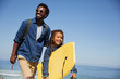 © Sam Edwards/Caia Image - Smiling father daughter with boogie board on sunny summer ocean beach