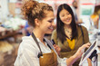 © Caiaimage/Paul Bradbury/Caia Image - Female cashier helping customer at touch screen cash register in grocery store