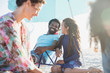 © Sam Edwards/Caia Image - Smiling father and daughter on sunny summer beach