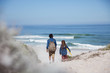 © Sam Edwards/Caia Image - Father daughter walking with boogie board on sunny summer ocean beach