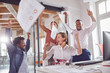 © Caiaimage/Rafal Rodzoch/Caia Image - Exuberant business people celebrating, throwing paperwork overhead in office