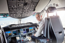 Portrait Confident Male Pilot In Airplane Cockpit