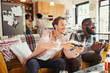 © Caiaimage/Paul Bradbury/Caia Image - Men friends playing video game in living room