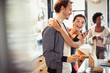 © Caiaimage/Paul Bradbury/Caia Image - Affectionate couple hugging, texting with smart phone in kitchen
