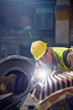 © Caiaimage/Agnieszka Olek/Caia Image - Focused steelworker with flashlight examining steel part in steel mill