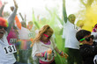 © Sam Edwards/Caia Image - Playful crowd of runners throwing holi powder at charity run