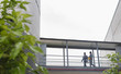 © Martin Barraud/Caia Image - Supervisors walking on elevated walkway between factory buildings