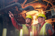 © Caiaimage/Agnieszka Olek/Caia Image - Steelworkers talking, pointing and looking away in steel mill