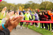 © Chris Ryan/Caia Image - Spectators clapping for runners nearing finish line at charity event