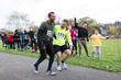 © Sam Edwards/Caia Image - Spectators cheering for man helping injured marathon runner