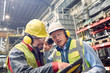 © Caiaimage/Agnieszka Olek/Caia Image - Steelworkers wearing ear protectors using digital tablet in steel mill