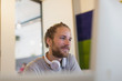© Sam Edwards/Caia Image - Confident creative businessman with headphones working at computer