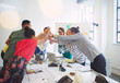 © Robert Daly/Caia Image - Enthusiastic architects high-fiving in conference room meeting