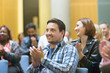 © TomMerton/Caia Image - Smiling man clapping in conference audience