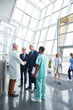 © Agnieszka Olek/Caia Image - Male surgeon greeting, shaking hands administrator businessmen in hospital lobby