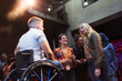 © Sam Edwards/Caia Image - Women in conference audience talking to speaker in wheelchair