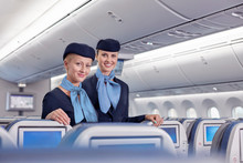 Portrait Smiling, Confident Female Flight Attendants On Airplane