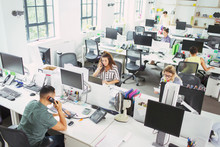 Business People Working At Desks In Open Plan Office