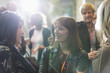 © TomMerton/Caia Image - Smiling businesswomen talking at conference