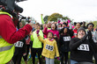 © Sam Edwards/Caia Image - Cameraman filming cheering crowd of runners at charity race