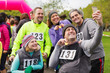 © Chris Ryan/Caia Image - Friends with medals taking selfie at charity race in park