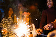 © Sam Edwards/Caia Image - Playful girl with sparkler celebrating with family