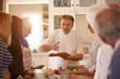 © Trevor Adeline/Caia Image - Senior friends listening to chef in pizza cooking class