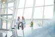 © Agnieszka Olek/Caia Image - Male doctors with clipboard talking in hospital lobby