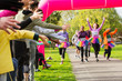 © Chris Ryan/Caia Image - Enthusiastic female runners in tutus nearing finish line at charity run in park