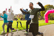 © Chris Ryan/Caia Image - Exuberant male runner cheering at charity run in sunny park