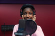 © Sam Edwards/Caia Image - Portrait confident teenage girl musician recording music, singing in sound booth