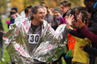 © Chris Ryan/Caia Image - Enthusiastic male marathon runner in thermal blanket high-fiving spectators
