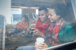 © Agnieszka Olek/Caia Image - Young couple coffee looking at digital camera at window on passenger train