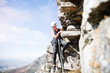 © Trevor Adeline/Caia Image - Female rock climber hanging from rock