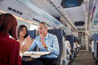 © Agnieszka Olek/Caia Image - Business people working, talking on passenger train