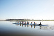 © Richard Johnson/Caia Image - Female rowing team rowing scull on tranquil lake