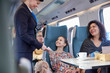 © Agnieszka Olek/Caia Image - Attendant checking ticket of mother and daughter on passenger train