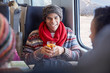 © Agnieszka Olek/Caia Image - Smiling young man drinking mulled wine on passenger train