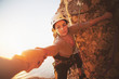 © Trevor Adeline/Caia Image - Focused female rock climber reaching for arm