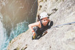 © Trevor Adeline/Caia Image - Focused, determined female rock climber scaling rock above sunny ocean