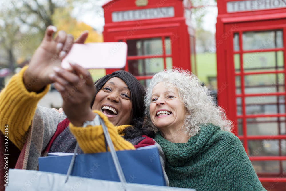 Smiling senior women friends taking selfie in park in front