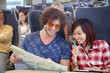 © Agnieszka Olek/Caia Image - Young couple looking at map on passenger train