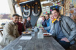 © Chris Ryan/Caia Image - Portrait smiling friends eating at restaurant outdoor patio