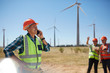 © Trevor Adeline/Caia Image - Smiling engineer talking on cell phone at sunny wind turbine power plant