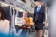© Agnieszka Olek/Caia Image - Attendant checking on businessman reading newspaper on passenger train