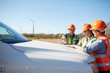 © Trevor Adeline/Caia Image - Engineers reviewing blueprint on truck at sunny wind turbine power plant
