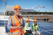 © Trevor Adeline/Caia Image - Portrait smiling, confident female engineer walkie-talkie at sunny solar power plant