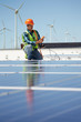 © Trevor Adeline/Caia Image - Engineer with equipment inspecting solar panels at sunny power plant