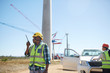 © Trevor Adeline/Caia Image - Male engineer with walkie-talkie at sunny wind turbine power plant