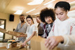 © Sam Edwards/Caia Image - Teenagers eating pizza in community center